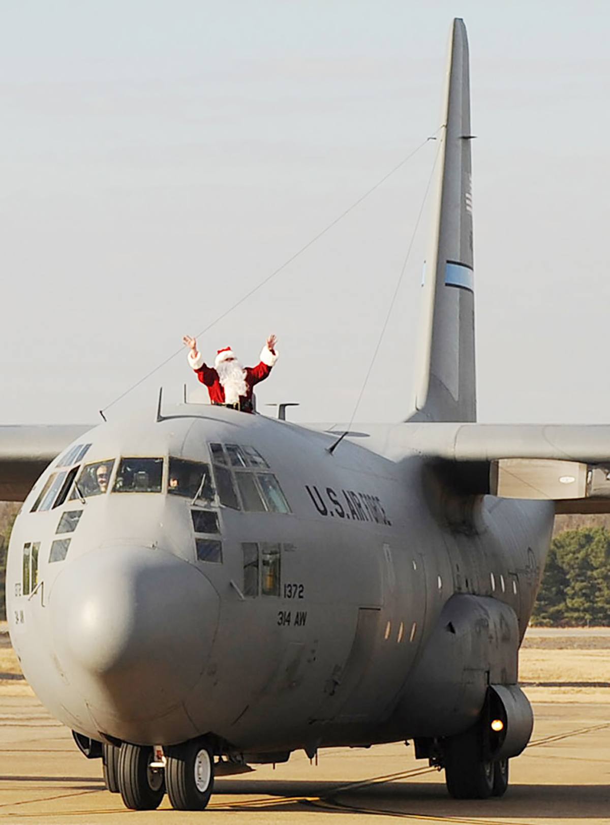 Santa Claus waves from a C-130 Hercules